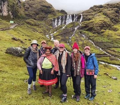 Travelers interacting with local villagers from an Andean community during the Lares Trek 4 Days 3 Nights tour, sharing traditions and cultural experiences in Cusco, Peru