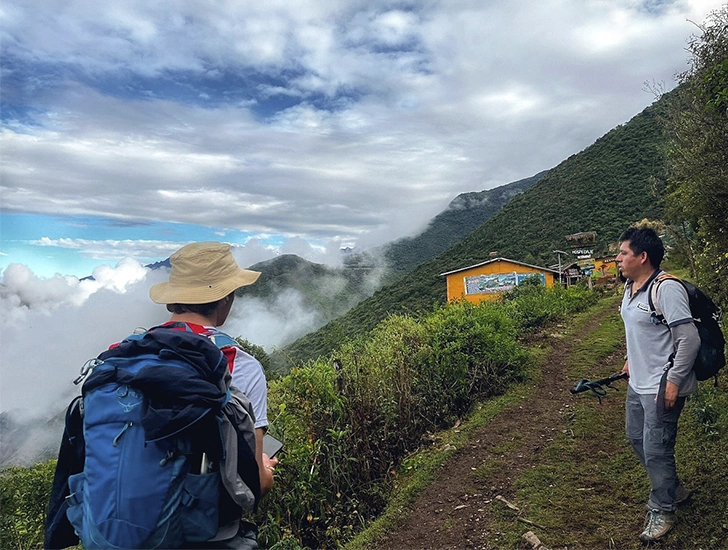 Turistas caminando por el sendero de montaña hacia Choquequirao rodeados de paisajes andinos
